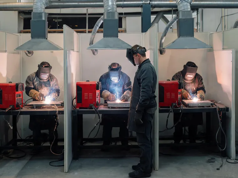 Welding students practicing beads on plate